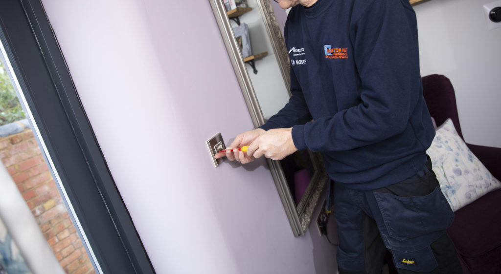 electrician adjusting a wall light socket